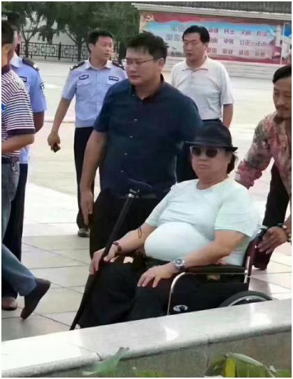 洪金宝独自坐轮椅买菜 认真挑选猪肉